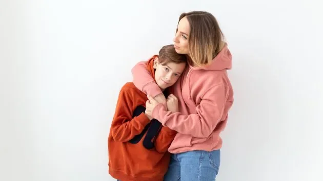 Une parent et son adolescent assis côté,à côte, en train de discuter
